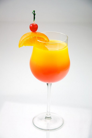 Tequila Sunrise garnished with orange and cherry, shot on a white background.